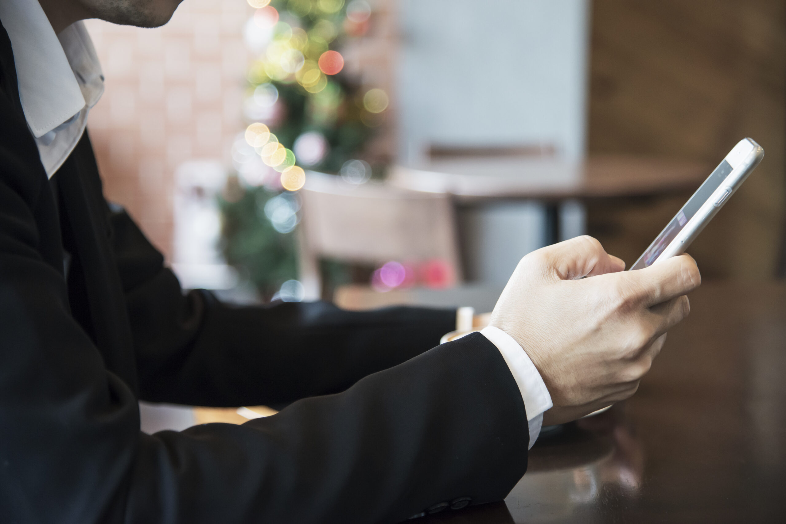 Business man using mobile phone while drinking coffee in coffee shop - modern life style business man in coffee shop concept